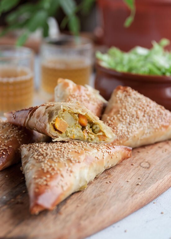 Curry samosa s bundevom i graškom prepolovljena na pola poslužena na dasci