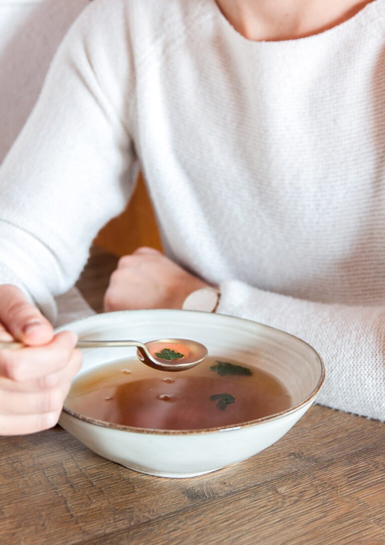 Tanjur pun temeljca na stolu, osoba koja žlicom uzima temeljac