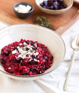 Rozi kremasti rižoto posipan feta sirom u dubokom tanjuru.